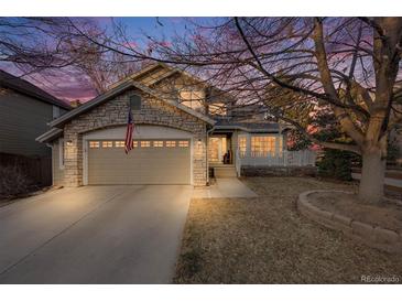 Charming home featuring a stone facade, two-car garage, and a cozy front porch at twilight at 2226 Weatherstone Cir, Highlands Ranch, CO 80126