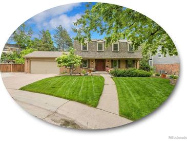 Charming home featuring a lush lawn, mature trees, and a welcoming front porch at 7030 S Fillmore Ct, Centennial, CO 80122