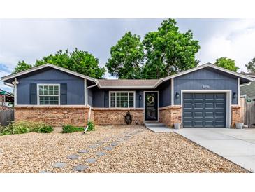 Charming single-story home with a brick foundation, blue siding, and a well-manicured front yard at 8696 W 86Th Cir, Arvada, CO 80005