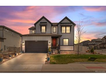 Charming two-story home with a well-manicured lawn and a spacious two-car garage at dusk at 6454 Leathers Ln, Parker, CO 80134