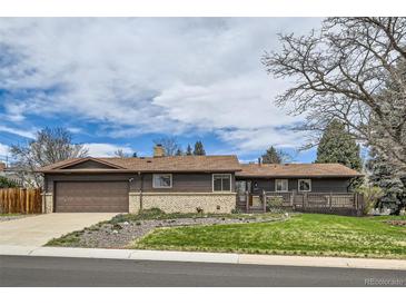 Charming single-story home featuring a cozy front porch, well-maintained lawn, and a two-car garage at 7245 W 70Th Ave, Arvada, CO 80003