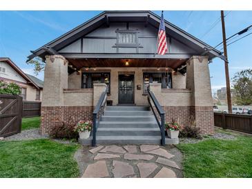 Charming brick home with a welcoming front porch, decorative planters, and an American flag at 1399 Newton St, Denver, CO 80204