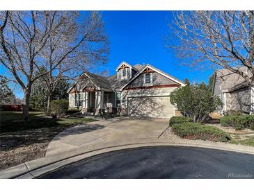 Charming home featuring a landscaped yard, two-car garage, and elegant architectural details at 1430 Bluefield Ave, Longmont, CO 80504