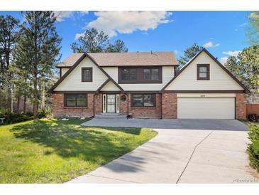 Charming two-story home with brick and vinyl siding, attached garage, and a well-manicured lawn at 8409 Lightening View Dr, Parker, CO 80134