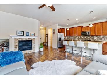Open-concept living area featuring a stone fireplace and direct access to the modern kitchen at 6284 Orion Ct # B, Arvada, CO 80403