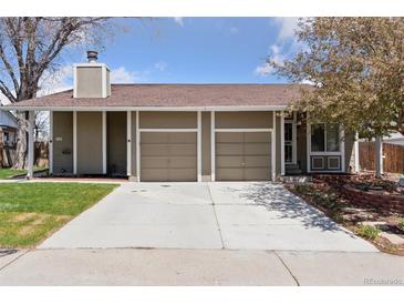 Charming home featuring a two-car garage and a well-maintained lawn and a clean concrete driveway at 15427 E Oberlin Pl, Aurora, CO 80013