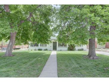 Charming home with mature trees, green lawn, and a concrete walkway leading to the front door at 2812 Krameria St, Denver, CO 80207