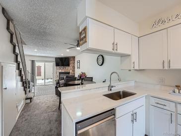 Modern kitchen featuring white cabinets, stainless steel appliances, and a view to the living room at 14222 E Hawaii Cir # F, Aurora, CO 80012