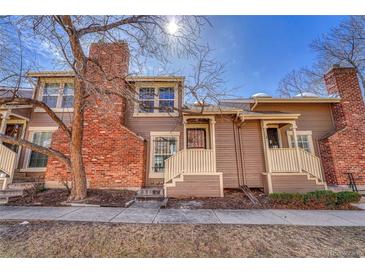 Charming townhome featuring a brick chimney, covered porch, and well-maintained facade at 2062 S Helena St # B, Aurora, CO 80013