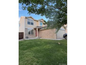 Charming two-story home featuring a lush green lawn, neutral siding, and a brick facade at 18897 E Linvale Pl, Aurora, CO 80013