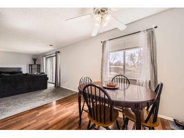 Cozy dining area featuring wood floors, a ceiling fan, and a view to the living room at 2201 Sable Blvd # 1008, Aurora, CO 80011