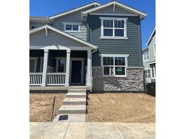 Charming two-story home with a covered porch, stone accents, and a modern design in a Gathering-friendly neighborhood at 15267 Fillmore St, Thornton, CO 80602