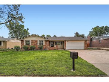 Charming brick home featuring a well-manicured lawn and an attached two-car garage at 678 S Oswego Ct, Aurora, CO 80012