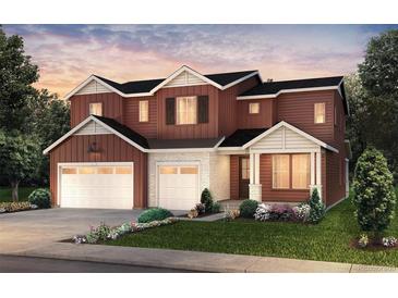 Inviting three-car garage home with a combination of white brick and brown wooden accents, landscaped front yard at 8576 Hotchkiss St, Littleton, CO 80125