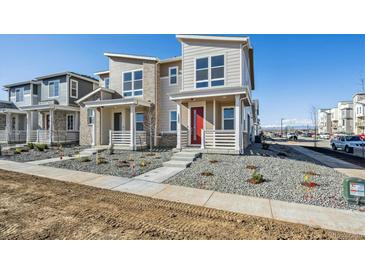Charming home with a red door, landscaped front yard, and a view of the mountains in the background at 1222 Penner Dr, Erie, CO 80026