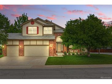 Charming two-story home boasts brick accents, a three-car garage, a manicured lawn, and inviting front porch seating at 1205 W 11Th Ct, Broomfield, CO 80020