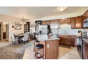 Open kitchen boasts stainless steel appliances, a breakfast bar, and ample cabinet space at 7292 S Blackhawk St # 2-204, Englewood, CO 80112