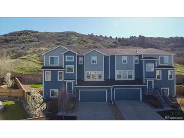 Modern townhouse with a two-car garage and a charming exterior, nestled near a scenic hillside at 1828 Blue Oak Ct, Castle Rock, CO 80104
