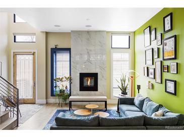 Bright living room features a fireplace, large windows, and blue accent rug at 2432 Champa St, Denver, CO 80205