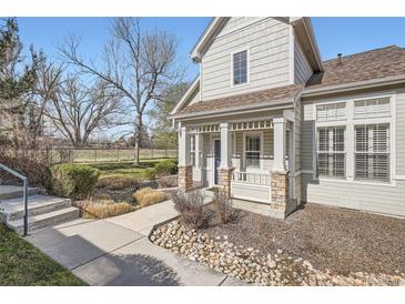 Charming home featuring a covered front porch, stone accents, and manicured landscaping, creating inviting curb appeal at 8300 Fairmount Dr # J105, Denver, CO 80247