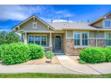 Charming home featuring manicured landscaping, stone accents, and a welcoming front porch at 8594 W Quarto Ave, Littleton, CO 80128