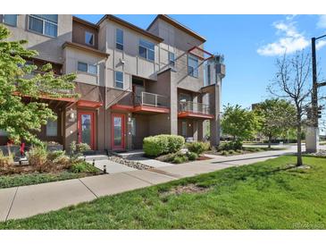 Modern townhome exterior featuring a well-maintained lawn and a neatly landscaped entrance at 8187 Martin Luther King Blvd, Denver, CO 80238