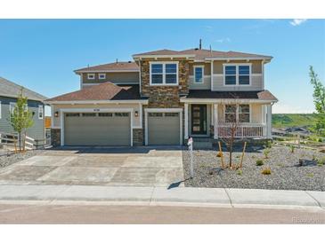 Beautiful two-story home with a three car garage, stone accents, and a welcoming front porch at 4728 Twelve Oaks Way, Castle Rock, CO 80104