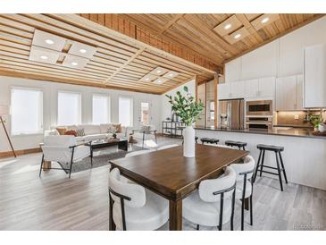 Bright open-concept living room and kitchen with wood plank ceiling and modern design at 2650 W Asbury Ave, Denver, CO 80219