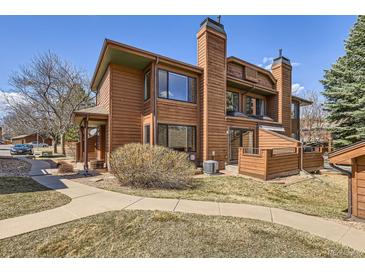 Charming two-story home boasts a warm wood exterior, complemented by mature landscaping and a welcoming walkway at 8040 Holland Ct # C, Arvada, CO 80005