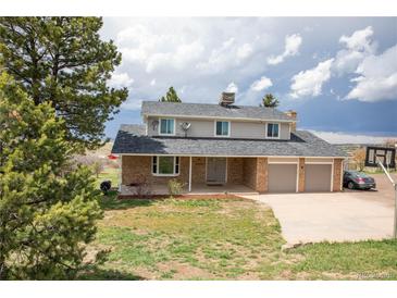 Charming two-story home with a brick facade and a well-maintained front yard and a two car garage at 10554 Tanglewood Rd, Franktown, CO 80116