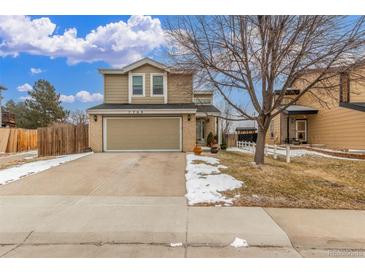 Inviting two-story home featuring a two-car garage and a well-maintained front yard with a touch of winter snow at 7768 Xavier Ct, Westminster, CO 80030