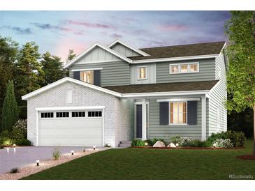 Charming two-story home featuring a two-car garage, a manicured lawn, and inviting curb appeal at 14155 Bunny Hop Ln, Parker, CO 80134