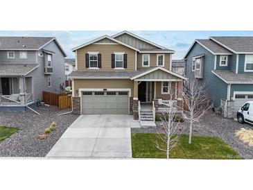 Charming two-story home featuring a well-manicured lawn, attached two car garage, and inviting front porch at 13144 E 109Th Pl, Commerce City, CO 80022