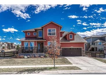 Two-story home with attached garage, stone accents, and well-manicured lawn at 21606 E Idyllwilde Dr, Parker, CO 80138