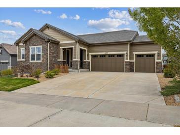 Charming home featuring stone accents and a spacious three-car garage, providing ample parking and curb appeal at 16902 W 94Th Pl, Arvada, CO 80007