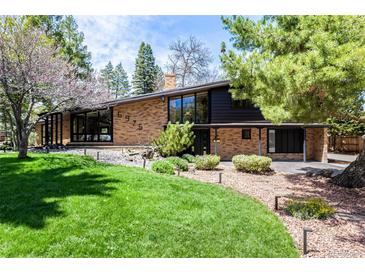 Stunning front exterior of the home featuring a brick facade, large windows, and a well-manicured lawn at 6975 S Chase Ct, Littleton, CO 80128