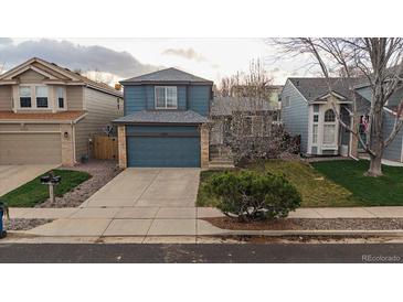 Charming two-story home with blue siding, a well-manicured lawn, and an attached two-car garage at 11539 Depew Ct, Westminster, CO 80020