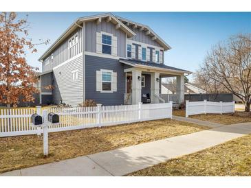 Charming two-story home featuring a welcoming front porch and white picket fence at 722 Hutchinson St, Louisville, CO 80027