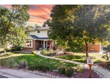 Charming two-story home with brick accents, a manicured lawn, and mature shade trees at 6906 S Sycamore St, Littleton, CO 80120