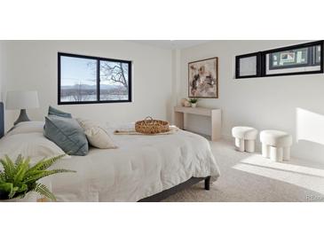 Bright bedroom featuring a queen-size bed, plush carpeting, modern decor, and a view from a large window at 1727 Lowell Blvd, Denver, CO 80204