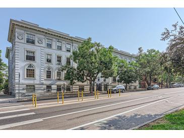 An exterior side view of a large apartment building showcasing its classic architectural design and surrounding streetscape at 215 E 11Th Ave # B9, Denver, CO 80203