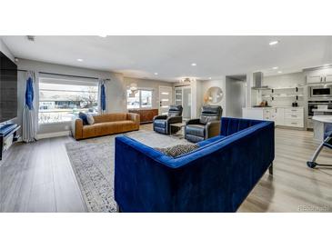 Bright open living room with light wood floors, large windows, and stylish modern furnishings at 4790 E Dartmouth Ave, Denver, CO 80222