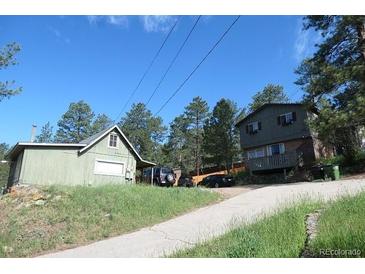 Exterior view of a house with a paved driveway and surrounding trees on a sunny day at 28127 Knowles Rd # Ab&C, Evergreen, CO 80439