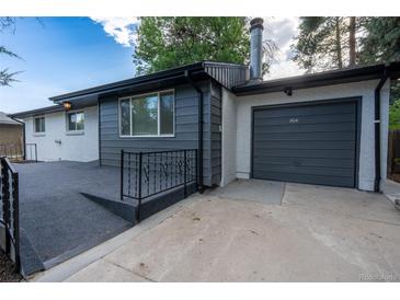 Charming home exterior with modern siding, a gray-toned garage, and beautifully landscaped front yard at 5041 S Julian St, Englewood, CO 80110