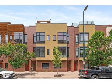 Contemporary townhome featuring a brick facade, large windows, and a rooftop deck at 2325 Walnut St # 4, Denver, CO 80205