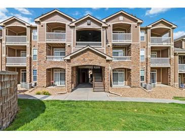 Beautiful condo exterior featuring stone accents, balconies, and well-maintained landscaping at 7440 S Blackhawk St # 14-103, Englewood, CO 80112