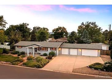 Ranch-style home featuring a three-car garage, mature landscaping, and a welcoming front porch at 6243 S Elati St, Littleton, CO 80120