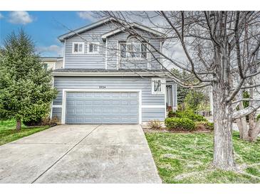 Charming two-story home with a well-manicured lawn and a gray two car garage door at 5934 S Yampa St, Aurora, CO 80016