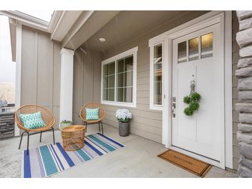 Inviting front porch with charming seating and decor, perfect for relaxing outdoors at 6657 S Kline Way, Littleton, CO 80127