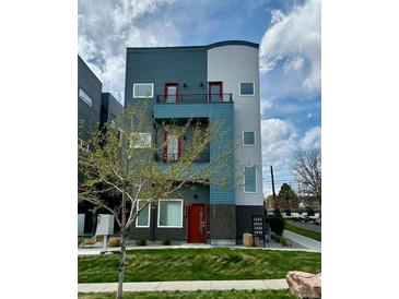 Modern three-story home with gray and blue facade, red door, and small front yard at 1299 Osceola St, Denver, CO 80204